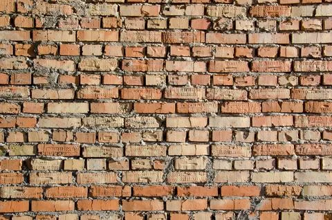 Old brick wall, old texture of red and orange blocks of stone. Closeup Stock Photos