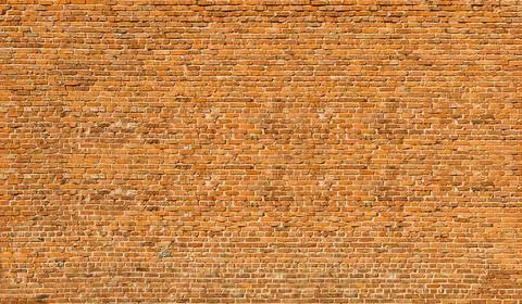 Old brick wall of red blocks with crumbling texture. Stock Photos