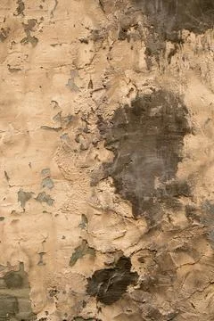 Old brick wall with severley damaged and patched stucco with intricate text.. Stock Photos