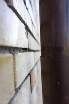 Old brick wall side view with nickel copper tube Foto stock