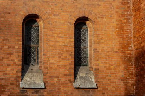 Old brick wall with tall arched windows and decorative frames in Riga Stock Photos