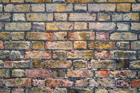 Old brick wall texture with various colours and pit marks in the bricks Stock Photos