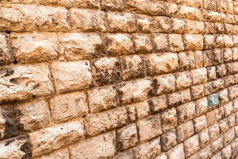 Old brick wall texture with weathered stone blocks and natural discoloration Stock Photos