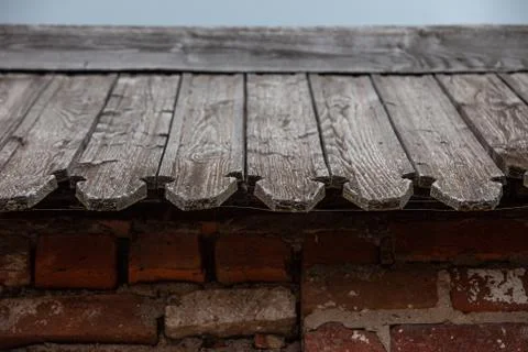 Old brick wall with timber roofing close up Stock Photos