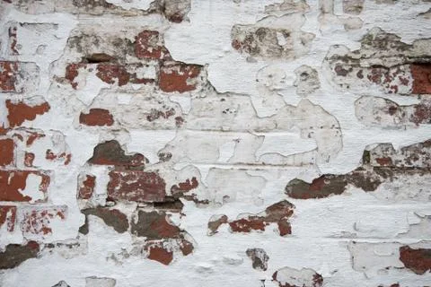 An old brick wall where the plaster is falling off. Background, texture. Stock Photos