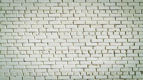 Old brick wall of white blocks with wide cracks between them Stock Photos