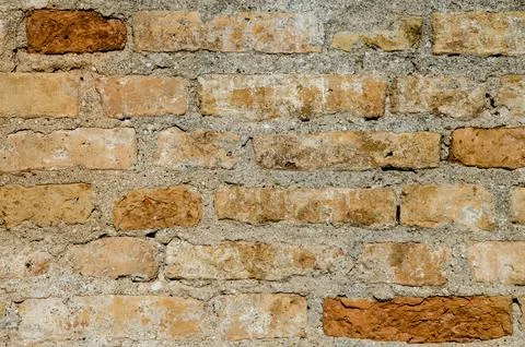 Old brick wall of yellow and orange color. The ruins of a dilapidated buildin Stock Photos