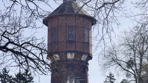 Old brick water tower framed by trees panning Stock Footage 333655735