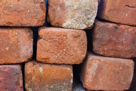 Old bricks used in construction stacked over one another Stock Photos