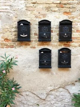 Old bricks wall with ancient post boxes, Italy Stock Photos