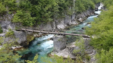 Old bridge across mountain river Stock Footage