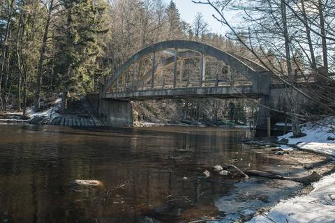 Old bridge across the river Spring landscape in April of a forest river. Snow Stock Photos