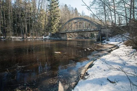 Old bridge across the river Spring landscape in April of a forest river. Snow Stock Photos