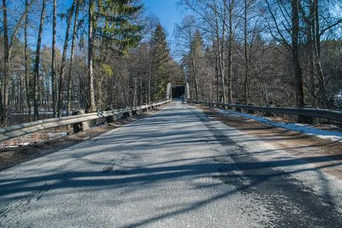 Old bridge across the river Spring landscape in April of a forest river. Snow Stock Photos