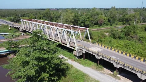 Old bridge crossed by many loaded trucks with a road full of holes Stock Footage 315259893
