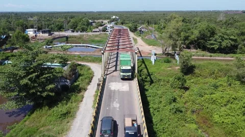 Old bridge crossed by many loaded trucks with a road full of holes Stock Footage 315259912