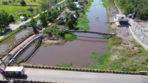 Old bridge crossed by many loaded trucks with a road full of holes Stock Footage 315259979