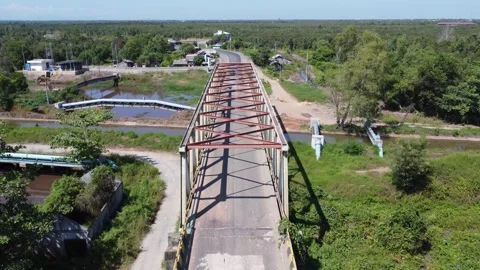 Old bridge crossed by many loaded trucks with a road full of holes Stock Footage 315260018