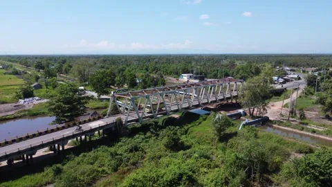 Old bridge crossed by many loaded trucks with a road full of holes Stock Footage 315260152