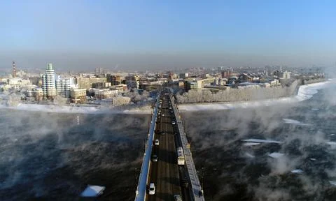 The old bridge over the Angara river. Steam is emitted from the water Stock Photos
