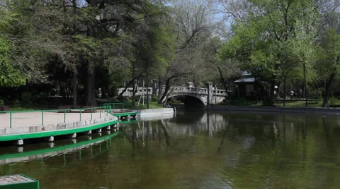 Old bridge over city park lake, beautiful spring day, people walking Stock Footage 37622830