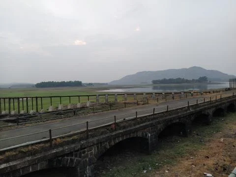 An old bridge over the meadow with almost zero traffic. Stock Photos