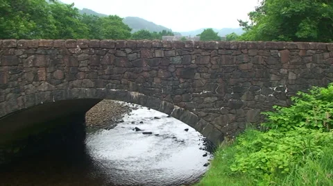 Old bridge over river flowing to camera, tilt and pan Stock Footage 39987892