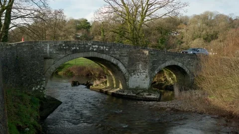 Old bridge over stream with car driving over the bridge Stock Footage 242621553