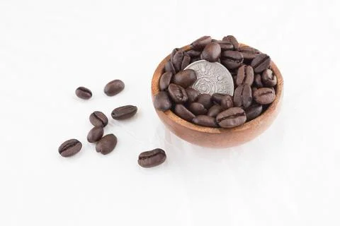 Old British Coin in stack of coffee beans Foto stock