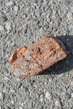 Old broken brick on the asphalt Stock Photos