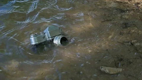 Old broken camera lost on the river bank Stock Footage 76825044