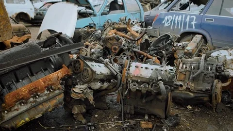 Old broken car engines are lying in big stack on a ground in an area of a plant Stock Footage 84021424