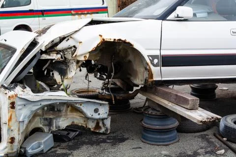 The old, broken car without wheels. Close up view on the front left side. Wre Stock Photos