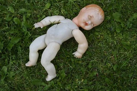 Old broken doll on a grass Stock Photos