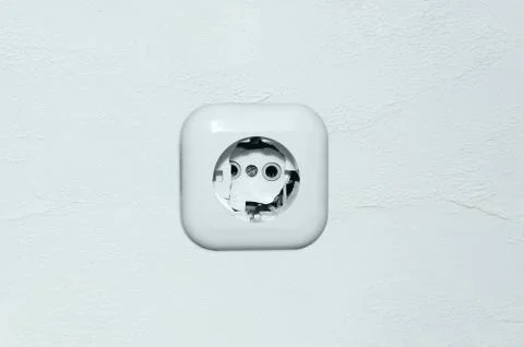 Old broken electrical white socket on the wall. Stock Photos