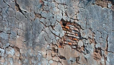 Old broken grey wall with red bricks Stock Photos