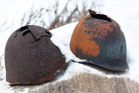 Old broken helmets Soviet World War on snow stone Stock Photos