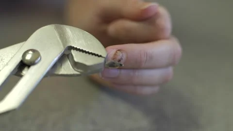Old broken rotten nail being peeled over with pliers Stock Footage 317650050