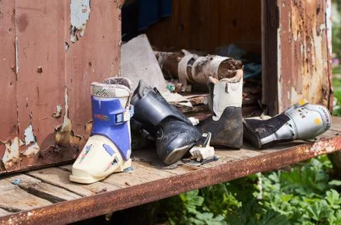 Old broken ski boots in rusty cabin Stock Photos