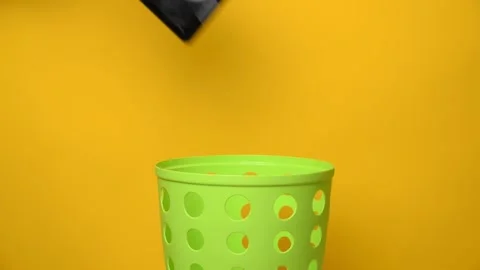An old broken tablet is thrown into a green trash can for recycling and disposal Stock Footage 194566350