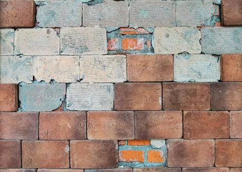 Old brown brick wall with partially destroyed facing. Stock Photos