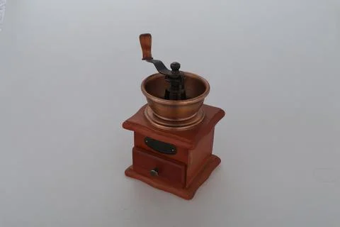 Old brown coffer grinder on the white table Stock Photos
