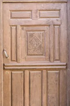 Old brown run-down religious decorated wooden door 스톡 사진