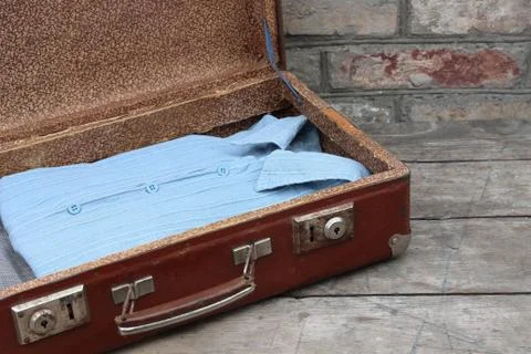 Old brown suitcase with clothes Stock Photos