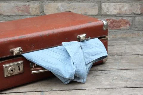 Old brown suitcase with clothes Stock Photos