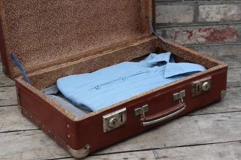 Old brown suitcase with clothes Stock Photos