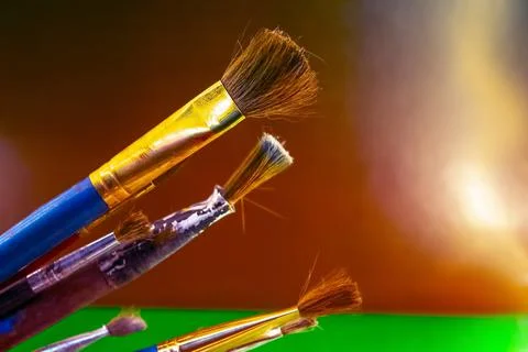 Old brushes for paint on a green background Stock Photos