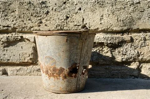 Old bucket on background of a cement wall Stock Photos