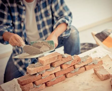 Old Builder craftman is leveling brick wall in vintage tone Stock Photos
