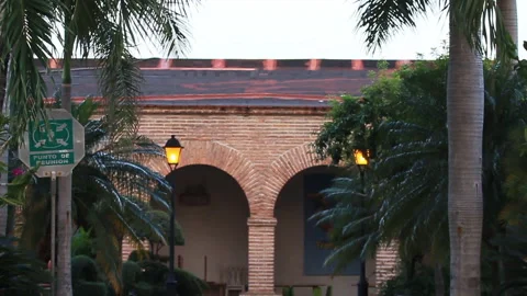 Old Building with Arches, Trees, and Street Sign in Dominican Republic Stock Footage 185093035
